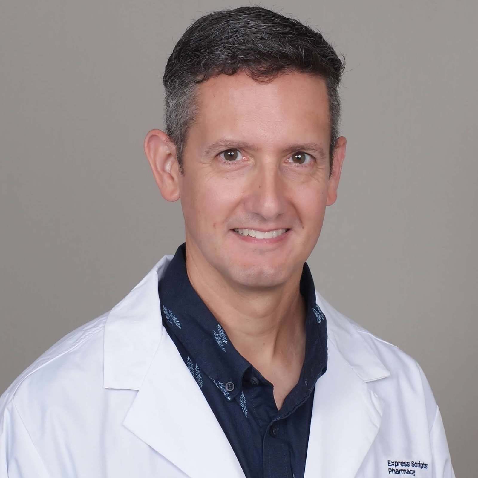 Registered pharmacist Brandon Fahs smiles in his Express Scripts Pharmacy lab coat.