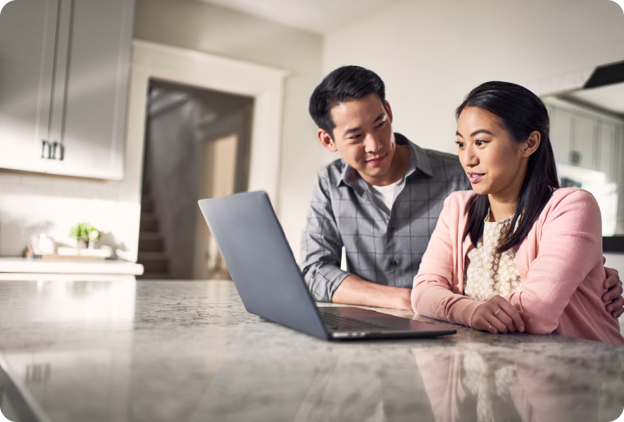 A man and woman review content on a laptop
