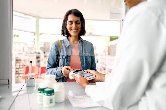 A woman pays for medication at the pharmacy