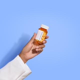 Pharmacist hand holding pill bottle
